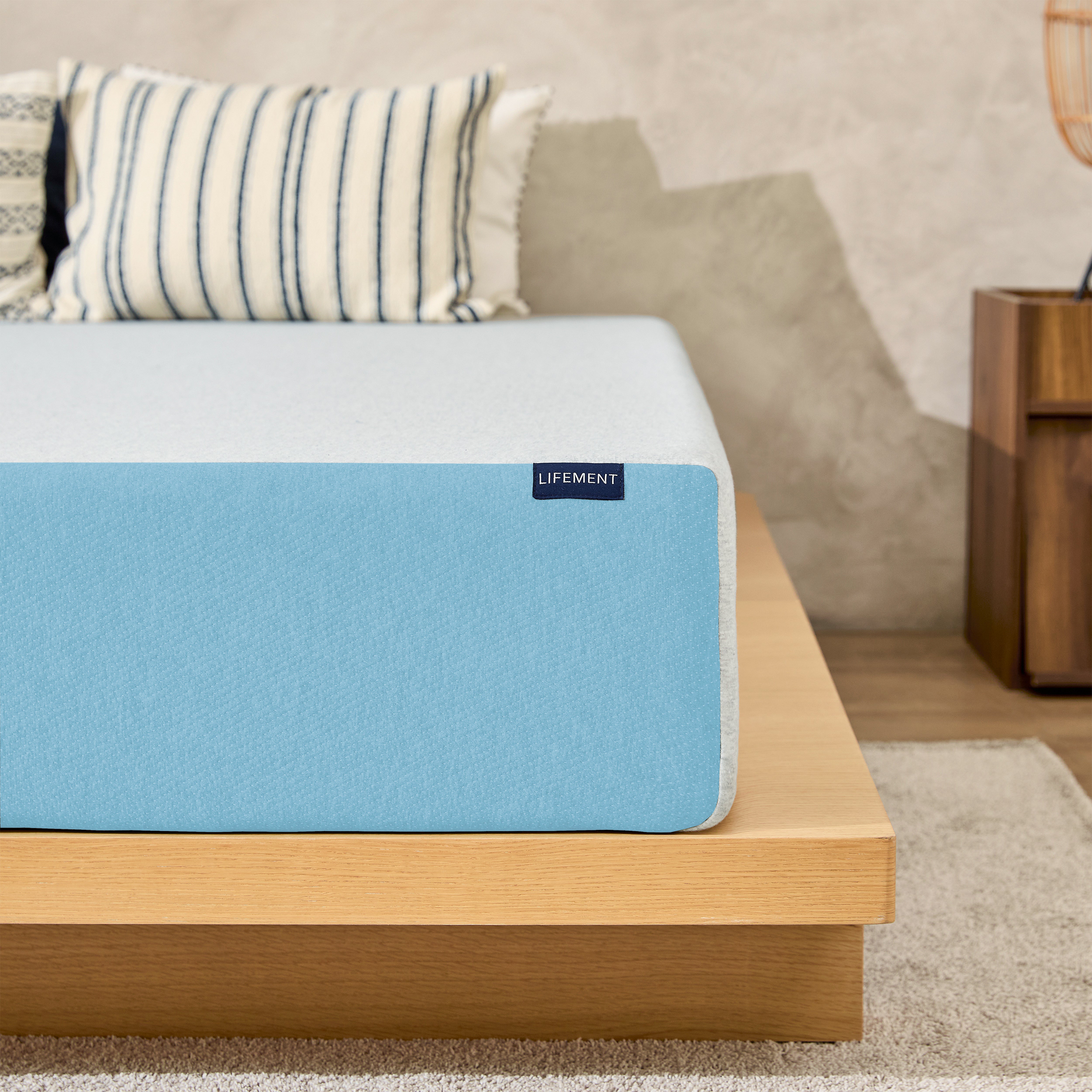 Lifement Basic Cooling Gel Memory Foam Mattress with light blue breathable cover on a natural wood bed frame in a bedroom with striped accent pillows