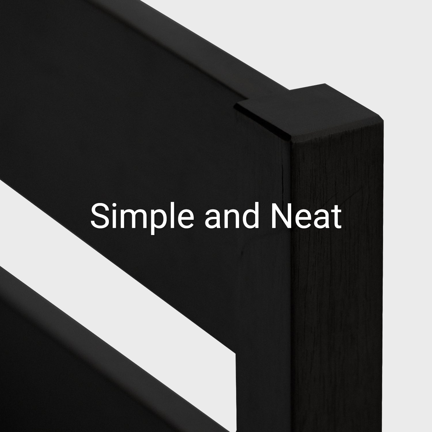 The edge of a headboard on a black wooden bedframe against a white background